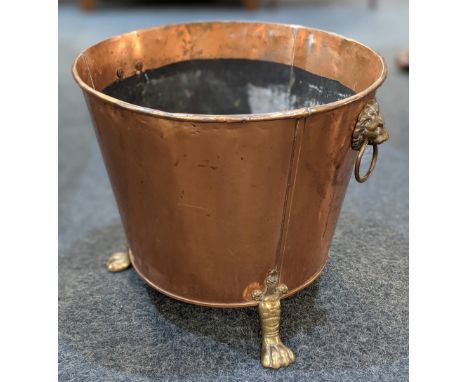 A copper and brass coal bucket, with lion's head and ring handles, on three paw feet, 41cm high
