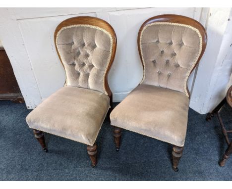 A pair of Victorian button back upholstered nursing chairs, on turned front legs and castors