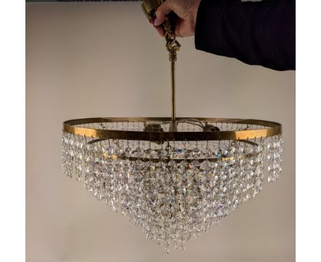 A circular brass six tier chandelier light fitting with hanging glass droplets, 43cm diameter