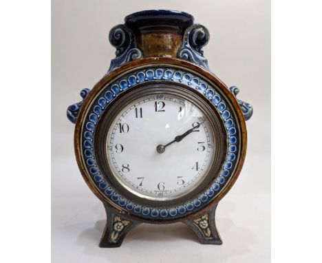 A Doulton Lambeth moon shaped mantle clock by Emily Welch, with circular enamel dial surmounted by a candlestick, 19.5cm high