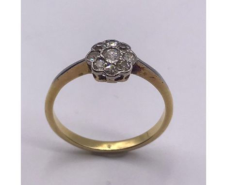 A Round Brilliant cut diamond centre, old cut diamond border daisy cluster ring. Center 2.7mm 0.07 carat J-K VS/SI Old Cut 1.
