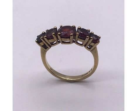 A 9 ct five stone ring, set with garnets (2.6g) Size K