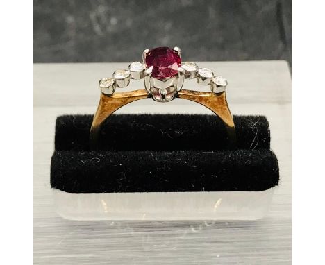 A 14 ct yellow gold ring with central ruby and three small diamonds to either side.