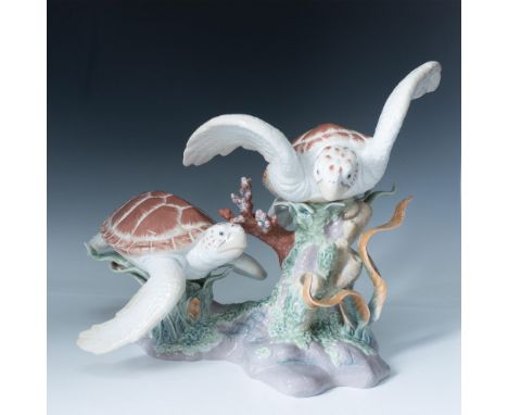 Stunning glossy figurine of two large porcelain sea turtles in shades of brown and beige swimming on the seabed. Seabed is la