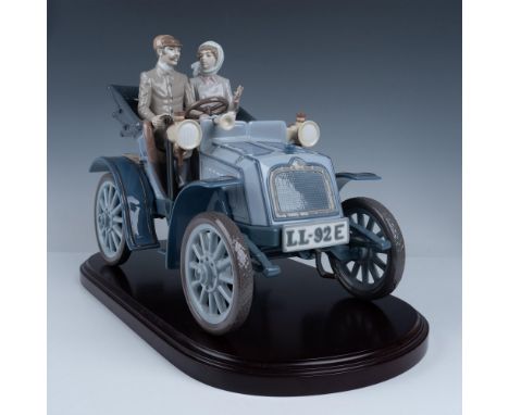 Glossy finish. Limited edition figure of a couple driving an early automobile. Lladro backstamp. This item has its original b