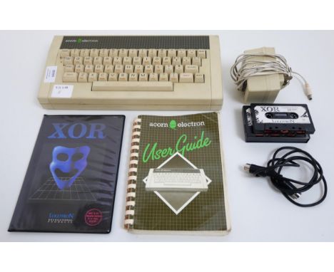 An Acorn Electron computer system with power cable, TV connection cable, user manual and XOR game (1 and 2)