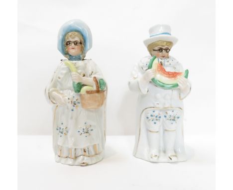 A pair of Victorian ceramic nodding figures of a male of eating watermelon and female holding a basket