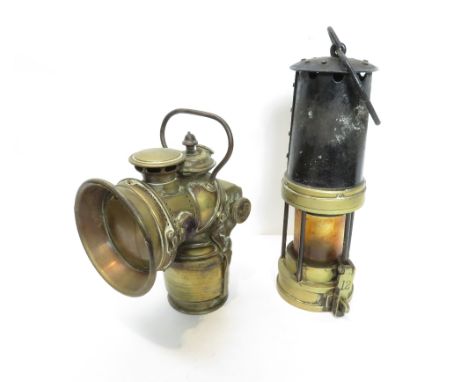 A vintage brass bike lamp, along with a miner's lamp