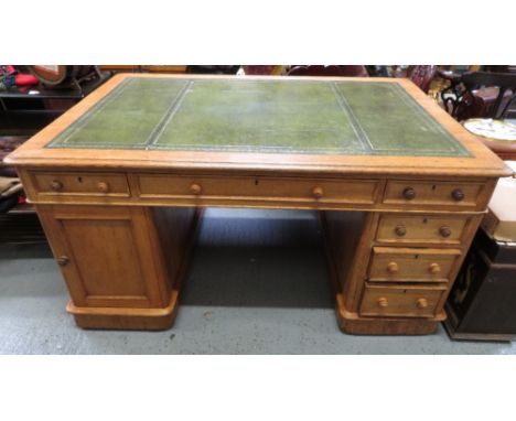 An early 20th century light oak partners desk with a green leather insert, each side set with one long drawer and two short d