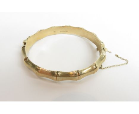 A 9 carat gold hinged bangle, simulating bamboo, 9 mm wide, internal diameter 6.2 cm, 15 g gross