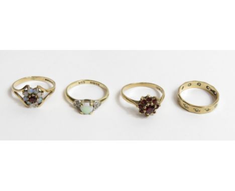 A 9 carat gold opal and diamond ring; a garnet and opal cluster ring; a garnet cluster ring; and a stone set eternity ring; 6