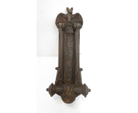 An early 20th century iron door knocker and letterbox, with a bat finial