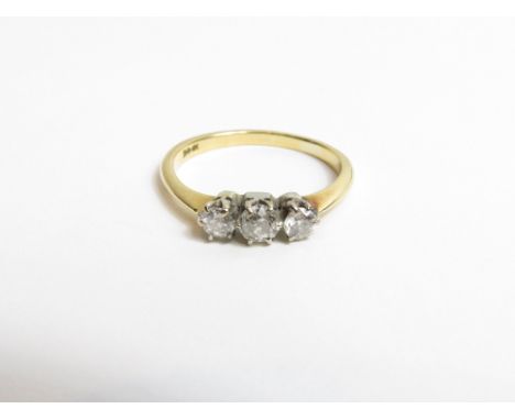 A three stone diamond ring, stamped '18ct', the graduated old cut stones totalling approximately 0.3 carats, finger size K1/2