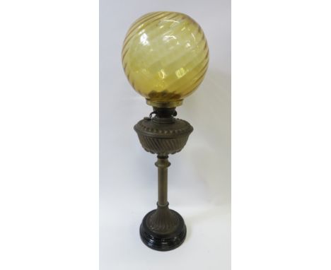 A 20th century brass stem oil lamp on a black pedestal base