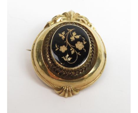 A 19th century gold brooch, with a floral decorated centre against a black enamel ground, 3.7 cm long, 10 g gross