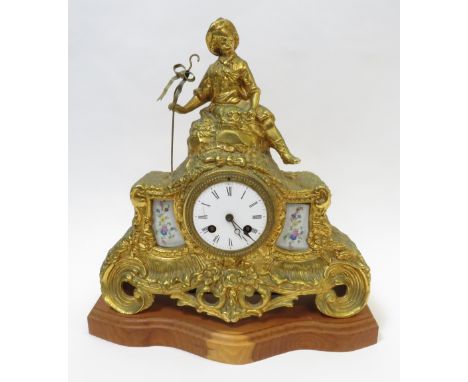 A 19th century gilt metal mantel clock with a eight day movement and two enamel panels each with a floral spray and figure of