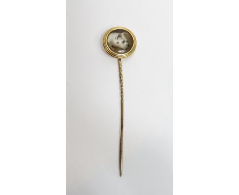 A W. Essex ceramic stick pin of a terrier, signed and dated to the reverse, date partially obscured by the mount, 2 cm diamet