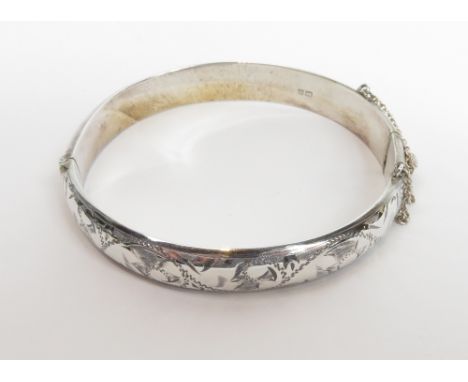 A silver hollow hinged bangle, with half engraved decoration, 16 g gross, cased