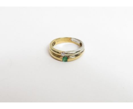 A 9 carat gold emerald and diamond ring, formed as two joined shanks, with a stone to each, the diamond set shank half white 