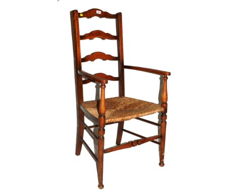 An Arts and Crafts elm ladder-back armchair with carved rails, hand woven rush seat with double stretcher supports