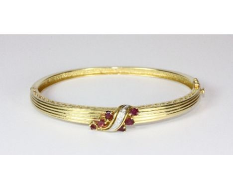 A heavy 18ct yellow gold hinged bangle set with rubies and diamonds (27g approx)