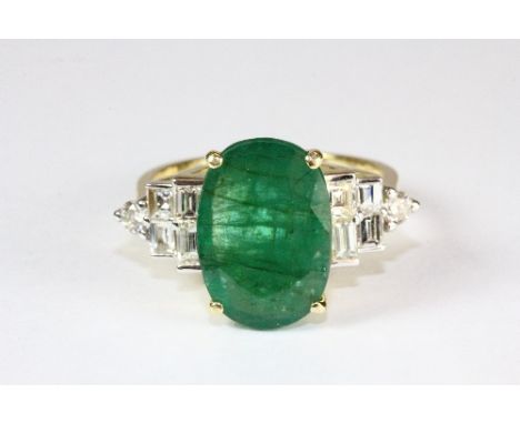 A superb 18ct yellow gold ring set with a large emerald (approx 4.09ct) with baguette and brilliant cut diamond shoulders (ap