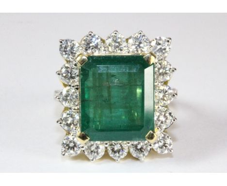 A superb 18ct yellow gold ring set with a large (10.7ct emerald) surrounded by approx 2.35ct of brilliant cut diamonds (O)