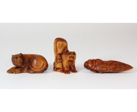 A carved fruitwood netsuke of a cicada with two small fruitwood figures of tigers all with onyx eyes
