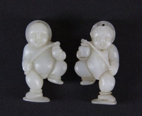 A pair of Chinese carved white jade amulets of baby boys, probably 19thC. H 4.5cm