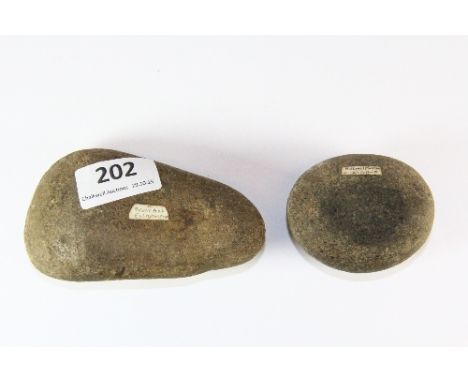 A stone age hollowed hammer head with a similar period stone axe head