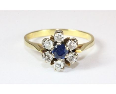 An antique 18ct yellow gold ring set with a sapphire surrounded by diamonds in a "trembler" setting (Q)