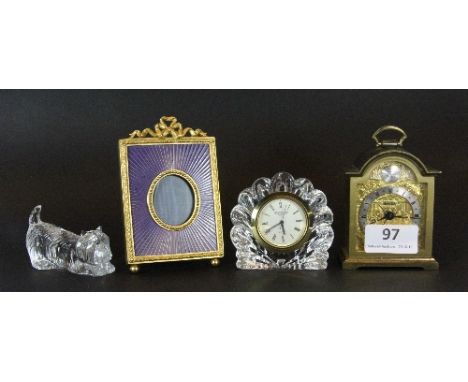 A Waterford Crystal clock, Waterford Crystal dog, a miniature brass bracket clock and an enamelled gilt brass photo frame