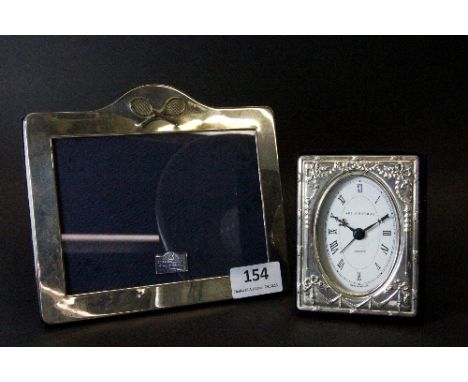 A hallmarked silver photo frame with tennis racket decoration and a hallmarked silver faced clock