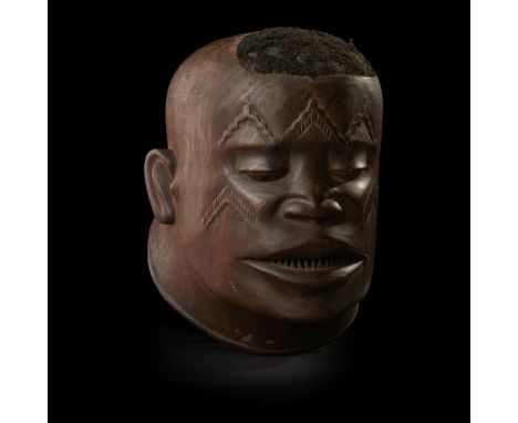 MAKONDE HELMET MASK, LIPIKOMOZAMBIQUE carved wood and hair, with scarification on the cheeks and the forehead, the mouth open
