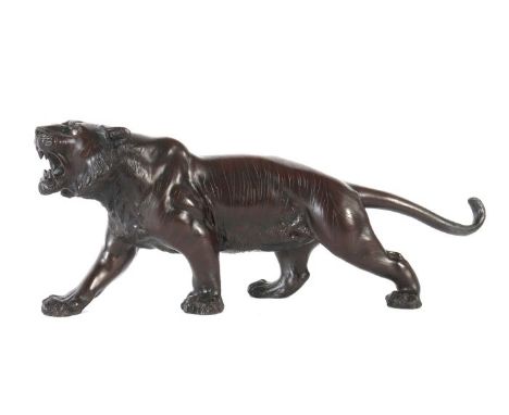 Großer TigerJapan, Anfang 20. Jh., Bronze, brüllender Tiger in ausschreitender Haltung, den Schwanz langgestreckt, mit Glasau