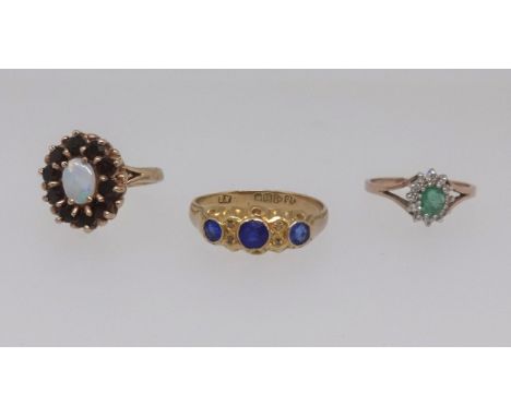 A 9ct opal cluster ring, an 18ct antique three stone sapphire ring, size U and a 9ct dress ring (3).