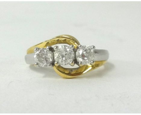 An 18ct white and yellow gold three stone diamond ring, stamped 750.