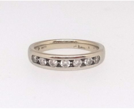 An 18ct white gold and diamond channel set eternity ring, size K, with original purchase receipt dated 2009.