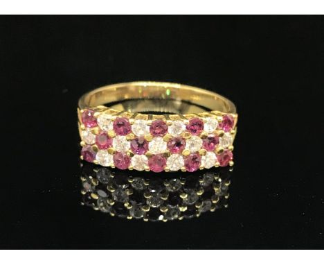 An 18ct ruby and diamond ring set with three rows of alternate stones, size N.