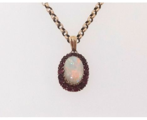 A ruby and opal cluster pendant set on a yellow metal chain, unmarked.