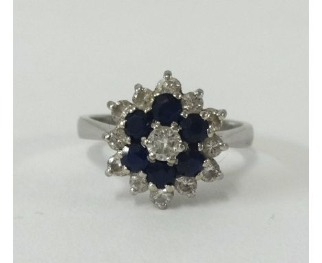 An 18ct sapphire and diamond cluster ring, size N.