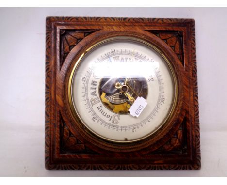 A wall barometer in carved oak case 