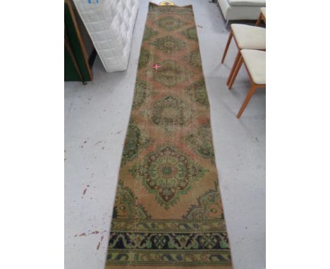 An antique carpet runner, 381 cm x 78 cm 