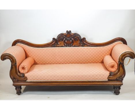 A mid 19th century carved mahogany double ended sofa with bow shaped back set a central scrolled foliate panel over two simil