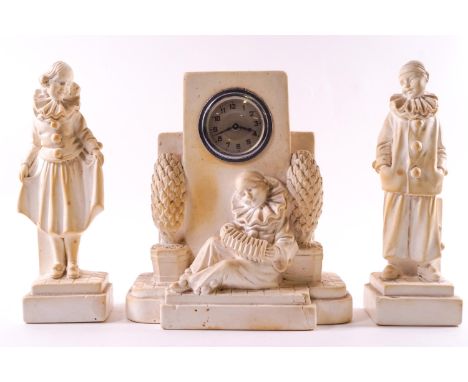 A 1930's composition garniture set of a clock with a pierrot playing an accordion 21cm high and two attendant figures of Pier