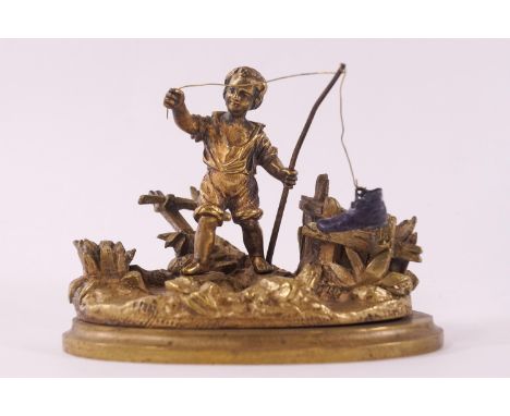 A 19th century Ormulu "go to bed" taper stick, modelled with a boy fishing and catching a boot, 19cm high, 11.5cm wide