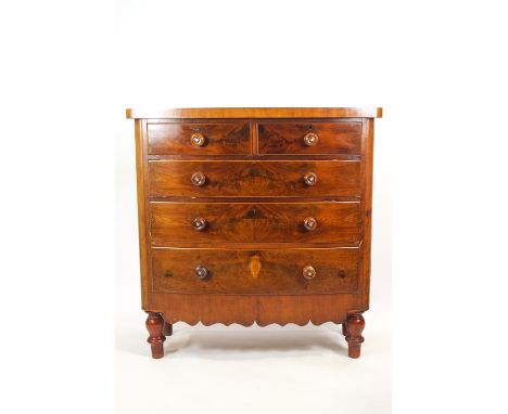 A 19th century mahogany bow front chest of two short and three long drawers set with turned wood handles with central mother 