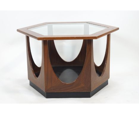 A G plan teak hexagonal coffee table, the top inset with a shaped glass panel, the whole raised on six inverted cut our arche