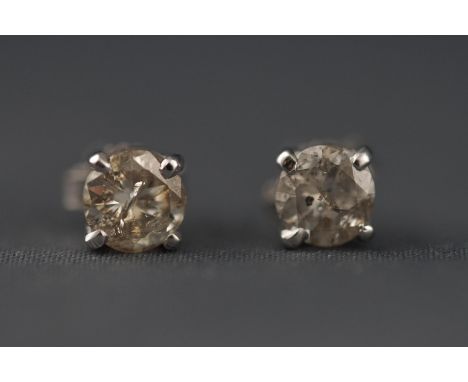 A white metal pair of single stone stud earrings. Each set with a round brilliant cut diamond of approximately 0.45 carats ea