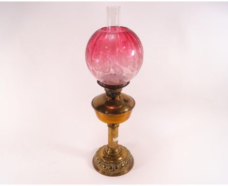 A Victorian oil lamp with etched cranberry tinted shade, on brass stand, 62.5cm  high